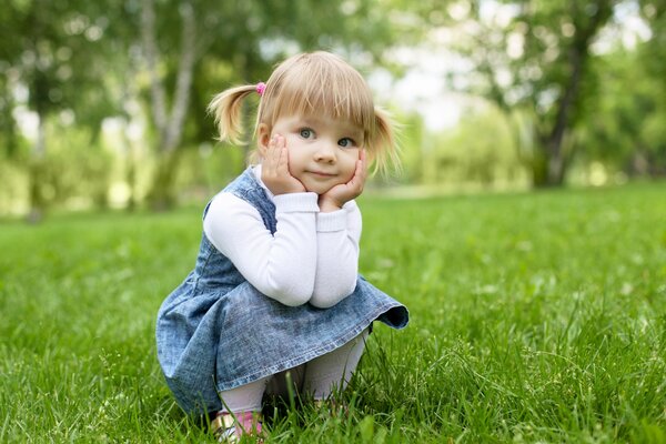 A little girl sat down to rest on the lawn