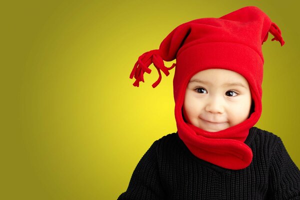 Портрет смешного стильного мальчика в красной шапке