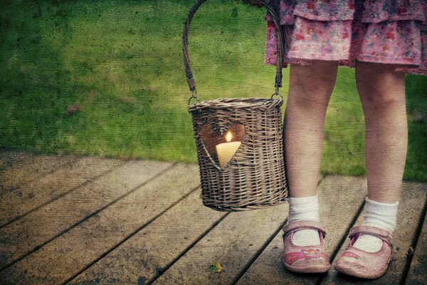 A little girl with a candle in a basket