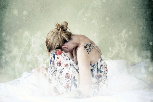 A girl with a tattoo on her back is sitting