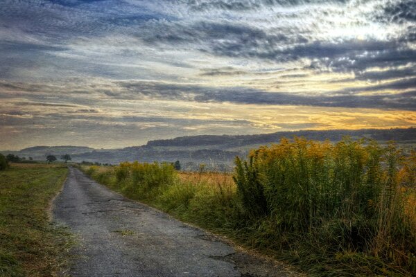 The road to the field under the sunset sky