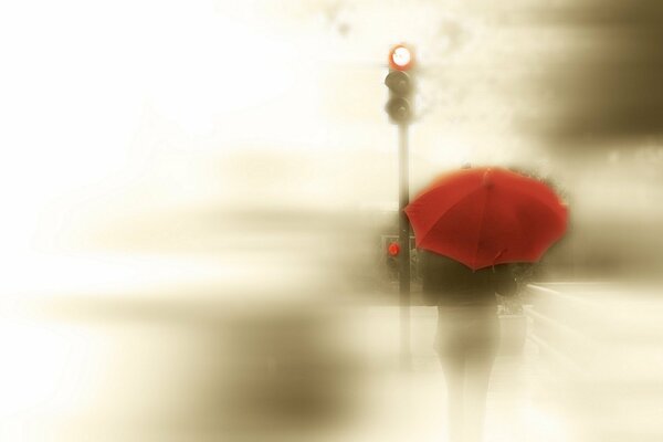 A blurry traffic light and a girl with a red umbrella