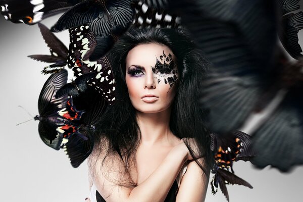 Foto eines Mädchens mit ungewöhnlichem Make-up und Schmetterlingen