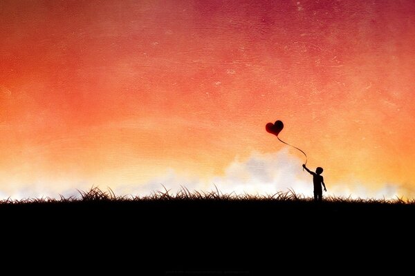 Мальчик на поле с шариком в форме сердца