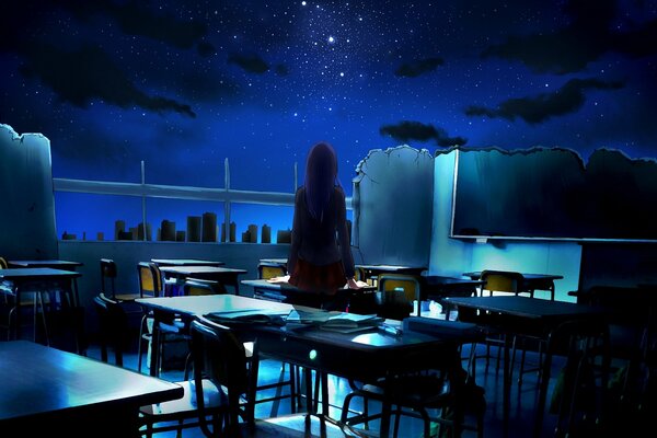 The girl is standing in the classroom at night