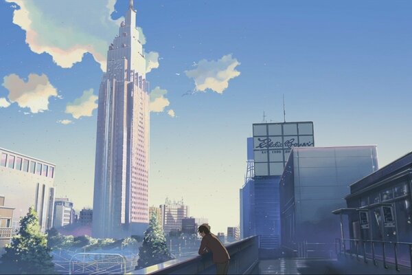 The guy is standing in the city among a skyscraper