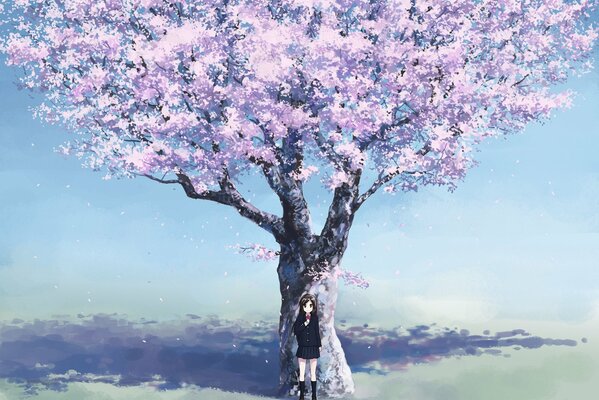 A schoolgirl girl stands under a large sakura tree in a field