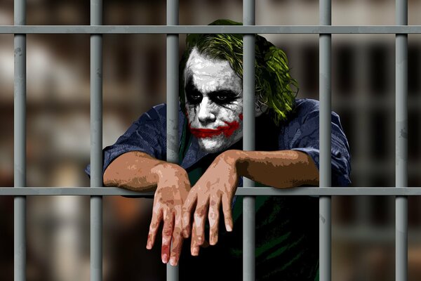 The joker is locked in a cell. The Joker is behind bars