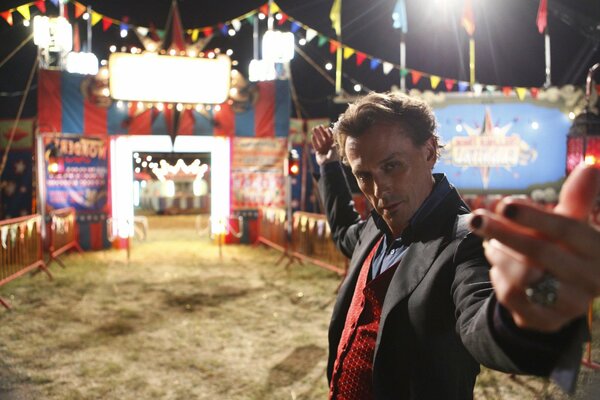 A man is photographed against the backdrop of a carnival