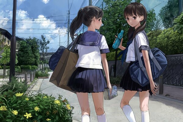 Painted schoolgirls walk down the street past a flower bed