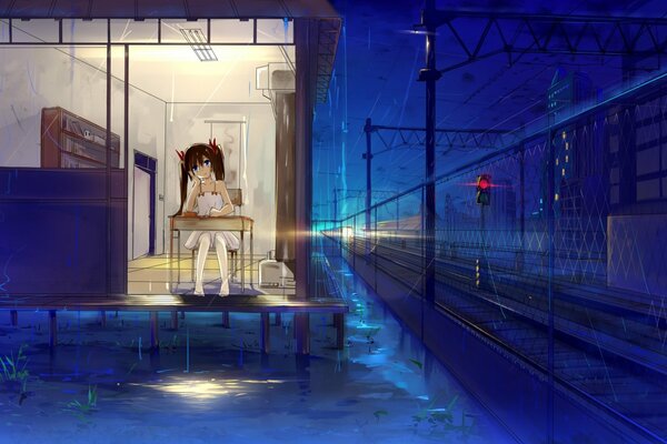The girl is sitting alone at night near the railway