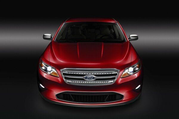 Ford rouge se dresse devant sur fond sombre