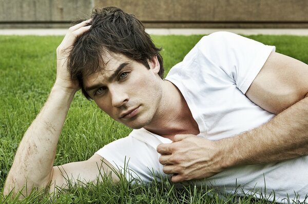 Actor Ian Sommerholdler is lying on the grass