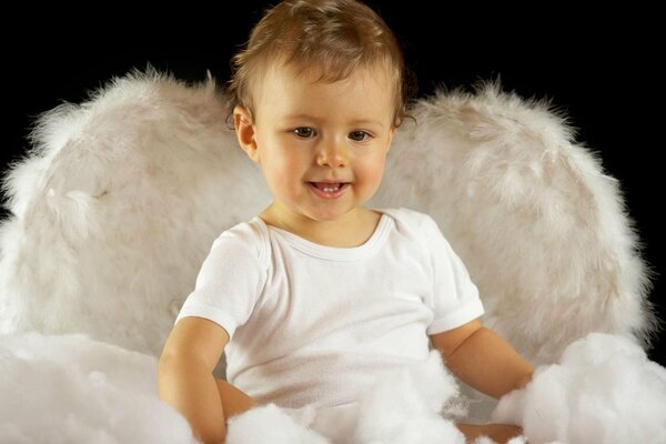 Niño pequeño en la imagen de un ángel para la foto