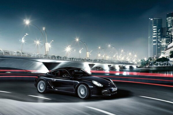 A black Porsche drives through the night city