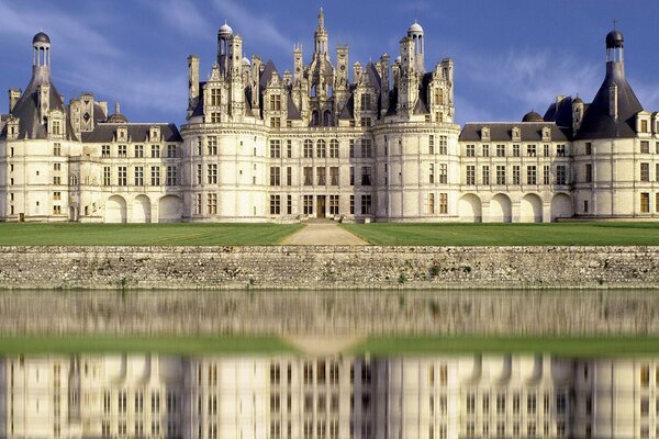 Schönes weißes Schloss reflektiert im Wasser