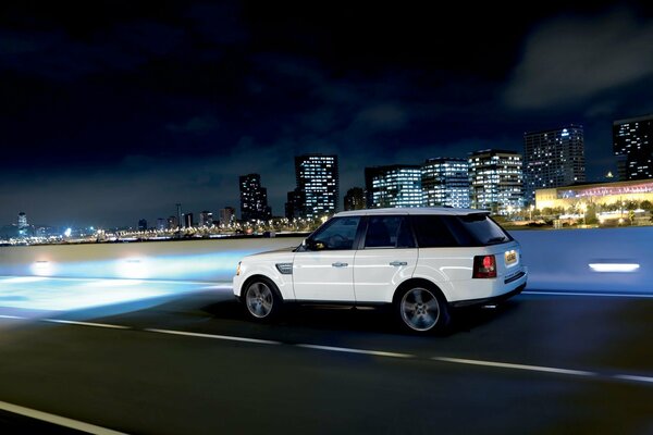 Sullo sfondo della città di notte Jeep bianca
