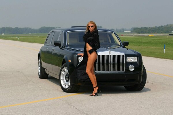 Chica de pie con Rolls Royce en el aeropuerto