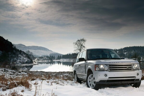 SUV on the background of snow and lake