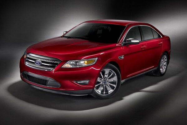 Red Ford Taurus on a black background