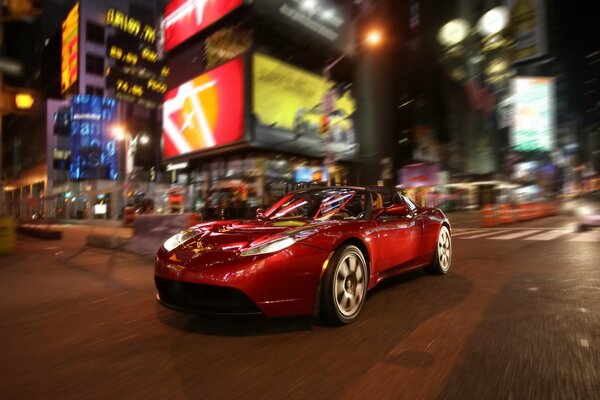 Driving through the night city on a red car