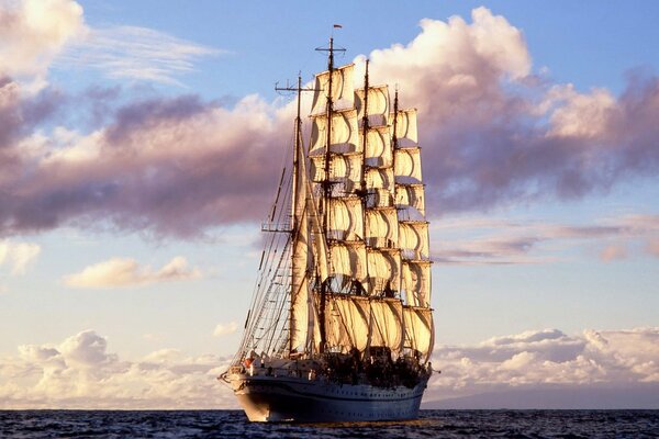 Velas de barco infladas por el viento del mar