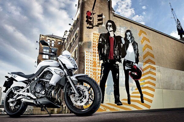 Motocykl na tle malowanych na budynku chłopaka i dziewczyny