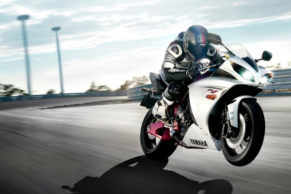Weißes Yamaha-Motorrad fährt mit hoher Geschwindigkeit