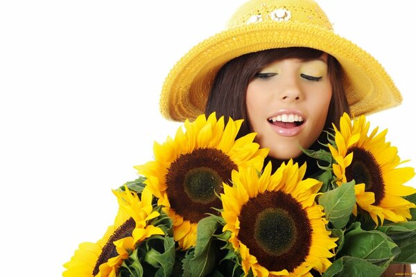 Bel viso con cappello vicino ai girasoli