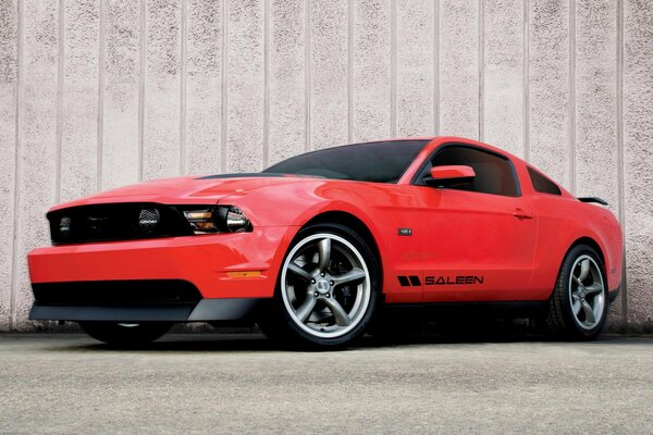 Mustang rosso su sfondo muro con vetri colorati