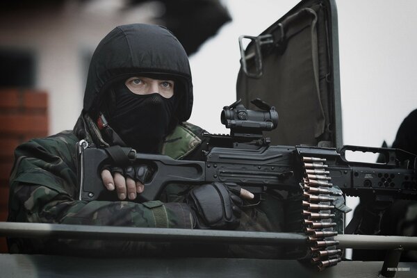A military man in a mask with a machine gun photo