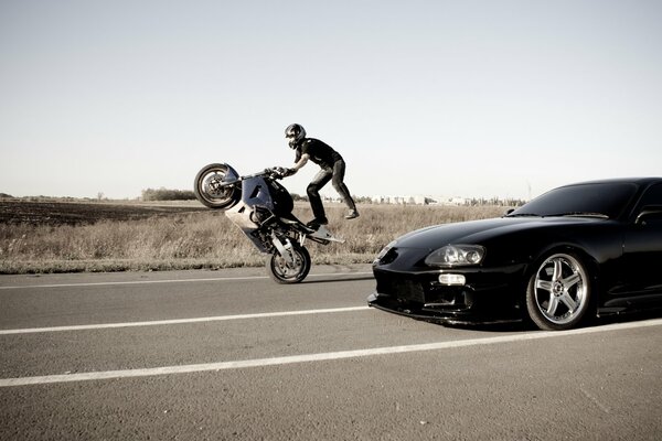 TOYOTA UND DER STUNTMAN AUF EINEM MOTORRAD REITEN