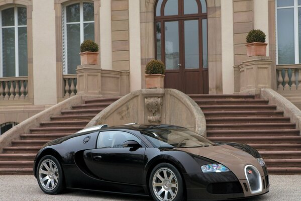 Black Bugatti hypercar at the steps of the building