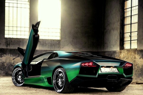 Lamborghini verde scuro in un edificio con grandi finestre