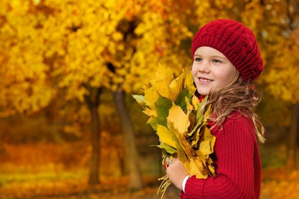 Mädchen mit einem Blumenstrauß aus Herbstblättern