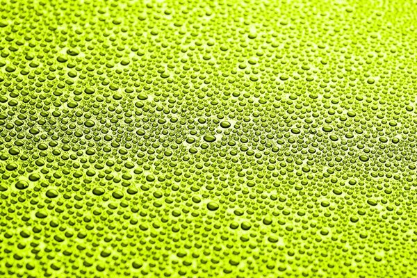 Макро съёмка капель воды на зелёном фоне