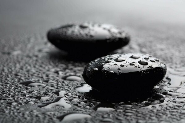 Black wet pebbles on a dark background