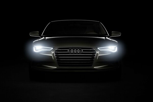 A car on a black background with shining headlights in the dark