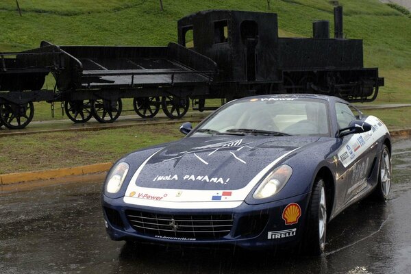 Ferrari na tle czarnej lokomotywy parowej