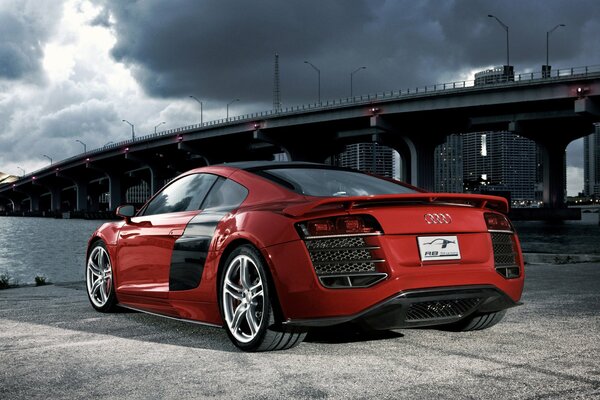 Audi rojo en el fondo del puente. Cielo nublado