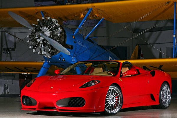 Roter Ferari im Hangar mit Flugzeug