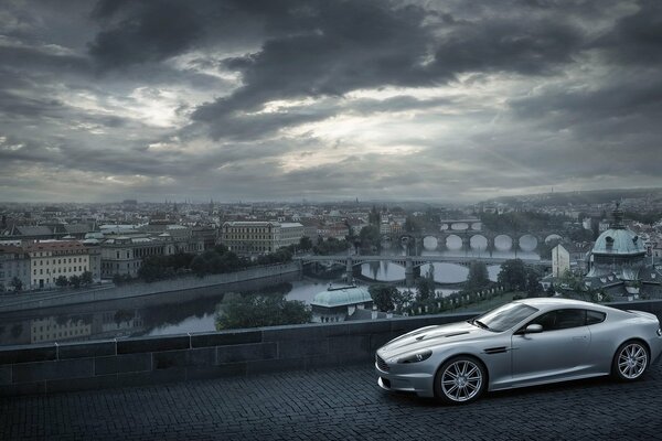 Aston Martin im Hintergrund der Stadt mit Wolken