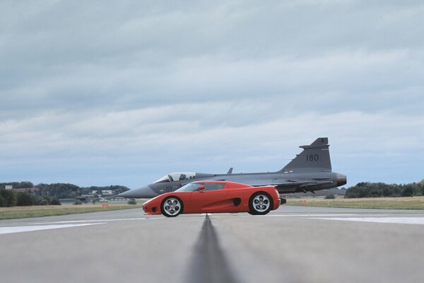 Red koenigsegg on the background of an airplane