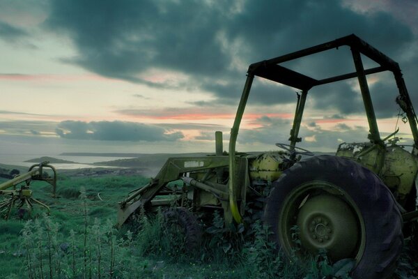 A broken tractor in the middle of a field