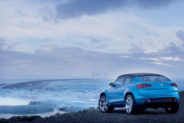 Blue car next to frozen water