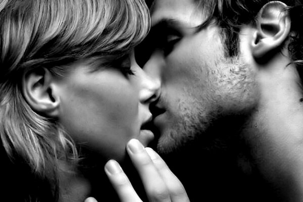 A girl with a square kisses a guy with stubble
