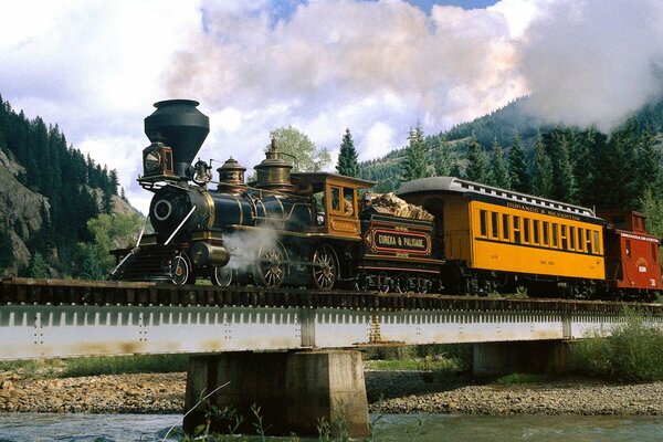 Die Dampflokomotive fährt vor dem Hintergrund der schönen Berge