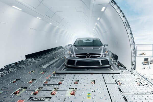 A gray Mercedes is flying in an airplane