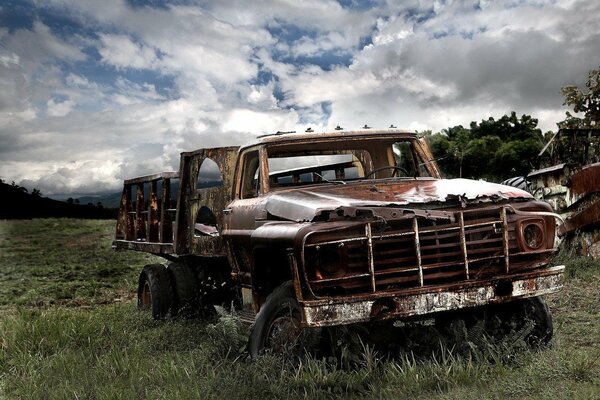 An old car truck in the middle of a field