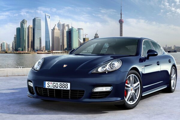 La Porsche blu si trova sullo sfondo di una bella città